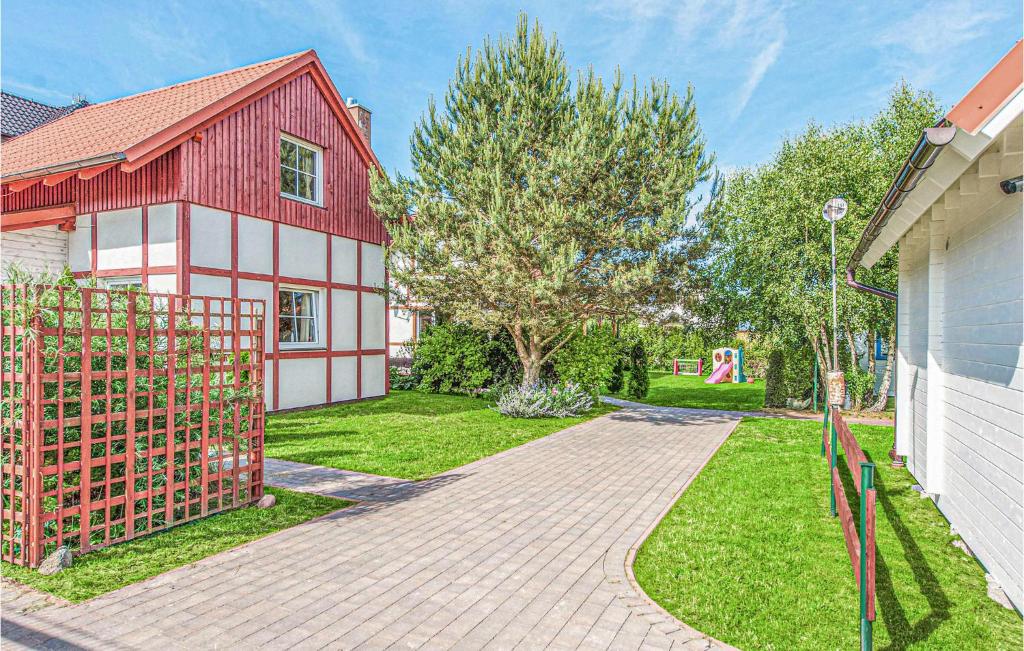 a red and white house with a gate in a yard at Awesome Home In Ustka With 2 Bedrooms And Wifi in Ustka