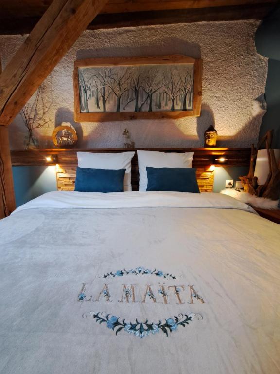 a bedroom with a white bed with aania written on it at La Maïta in Montgenèvre