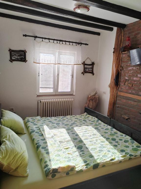 a bed with a quilt on it in a bedroom at Apartmani Mali Raj Rudnik in Rudnik