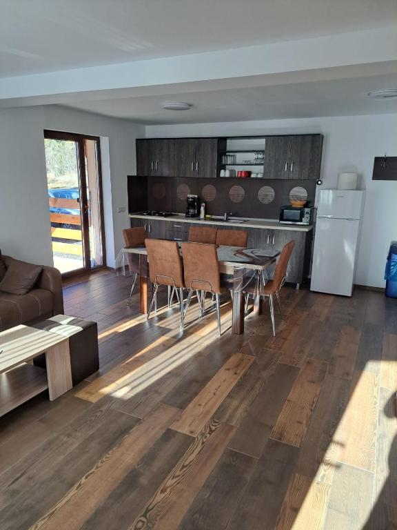 a kitchen and living room with a table and chairs at Enduro Transalpina in Obarsia-Lotrului