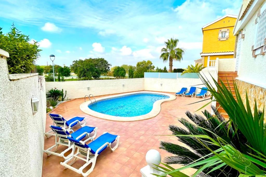una piscina con sillas azules y una piscina en 14 VILLA relax private pool, en Puerto Marino