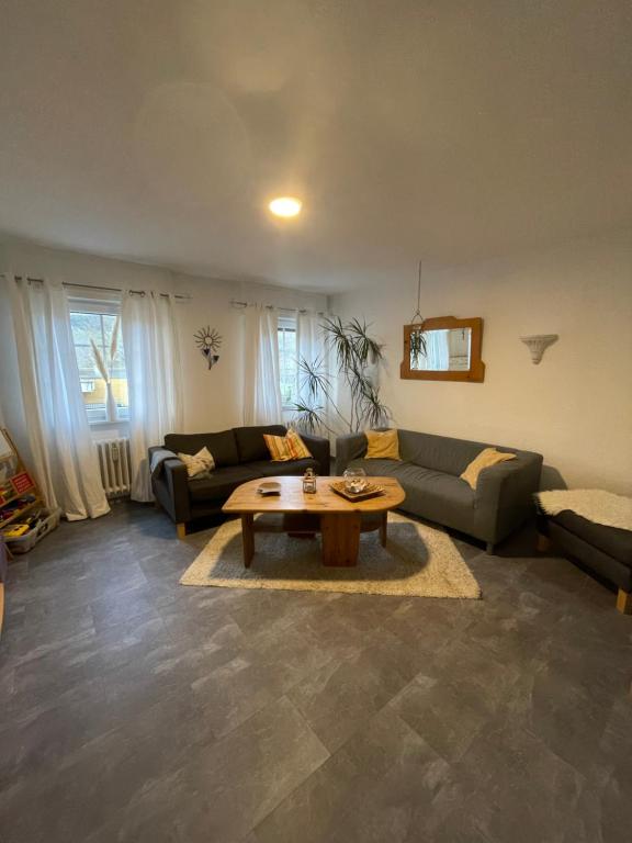 ein Wohnzimmer mit einem Sofa und einem Tisch in der Unterkunft Ferienwohnung & Apartment Am Steinbrunnen in Brauneberg