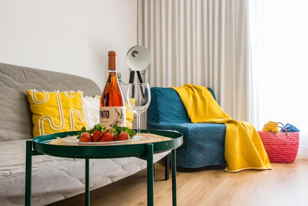 ein Wohnzimmer mit einem Tisch mit Obst und einer Flasche Wein in der Unterkunft דירת אירוח בירוחם - הקומה השניה in Jerocham