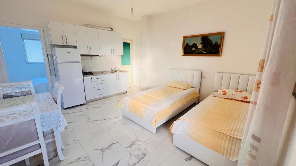 a bedroom with two beds and a kitchen with a refrigerator at Kleida Beach Vacation Rentals in Spille