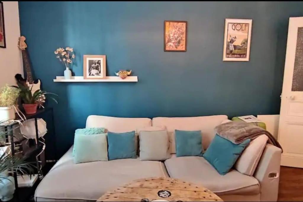- un salon avec un canapé blanc aux murs bleus dans l'établissement CŒUR MENOU, Radis'son & PARKING, à Nantes