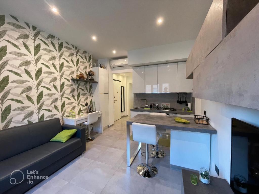 un soggiorno con divano e una cucina di R39 Modern Apartment with Private Parking a Milano