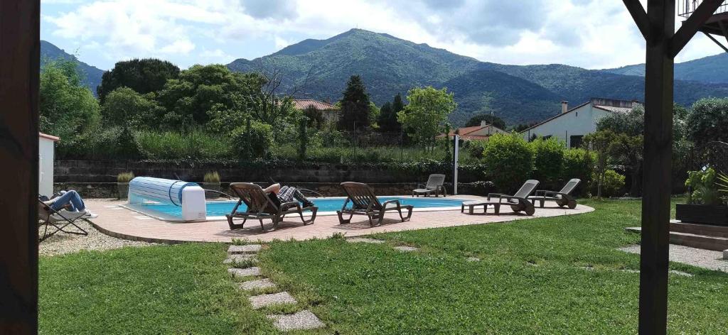 a group of chairs sitting next to a swimming pool at Chambres d&#39;hôtes et gîtes Al Pati in Sorède