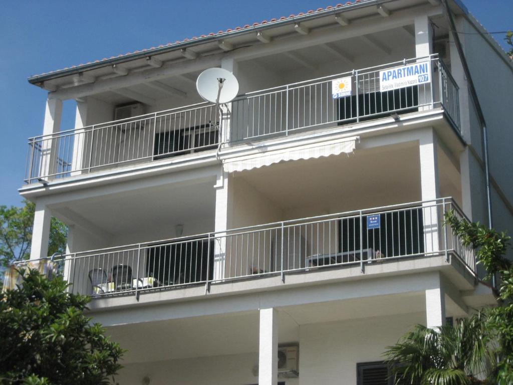 un edificio con balcones y un letrero en la calle en Apartments Sonne 2, en Crikvenica