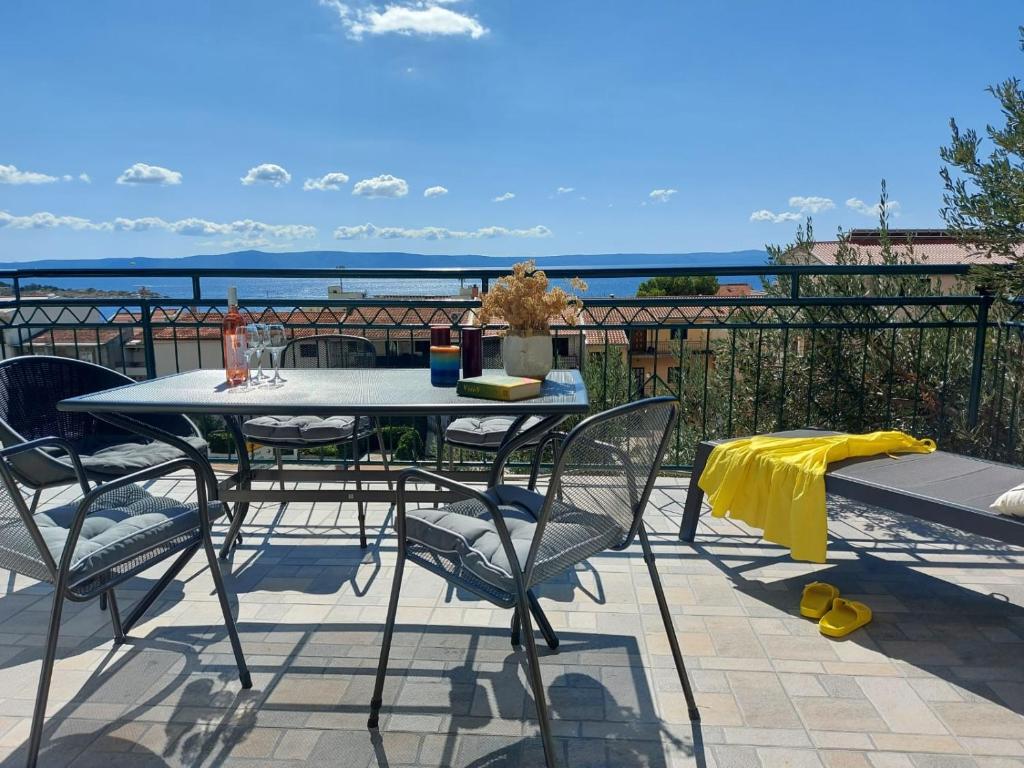 una mesa y sillas en un balcón con vistas al océano en Apartments Jana, en Makarska