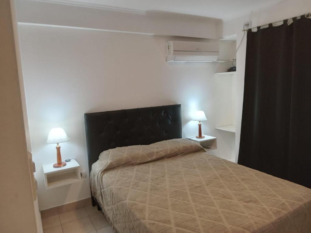 1 dormitorio con 1 cama y 2 lámparas en las mesas en Monteagudo 847 en San Miguel de Tucumán