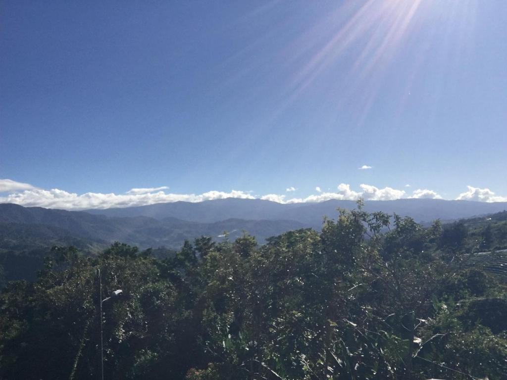 uma vista para as montanhas com o sol no céu em Casa de Cristal-Retiros Esenciales Costa Rica em Cartago