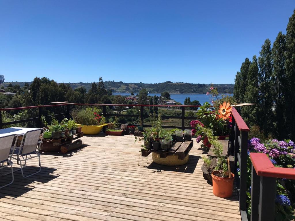 a deck with potted plants and a view of the water at Cabañas y hostal Aurora in Castro