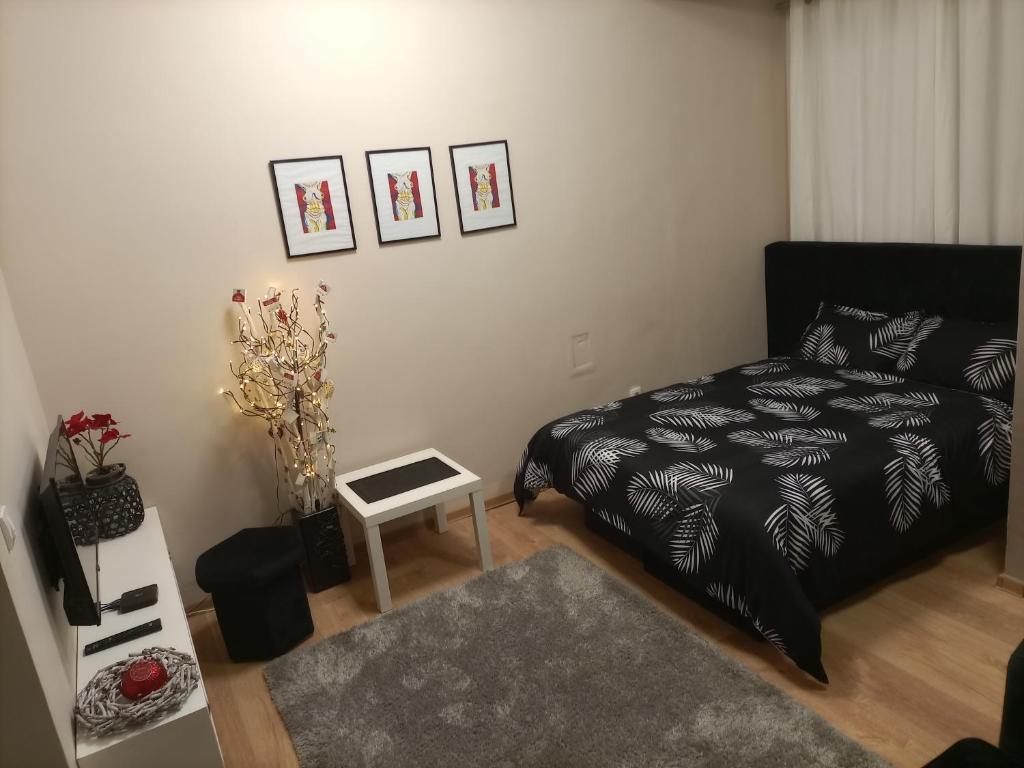 uma sala de estar com uma cama e uma mesa em Dvoriste Danguba em Nova Pazova