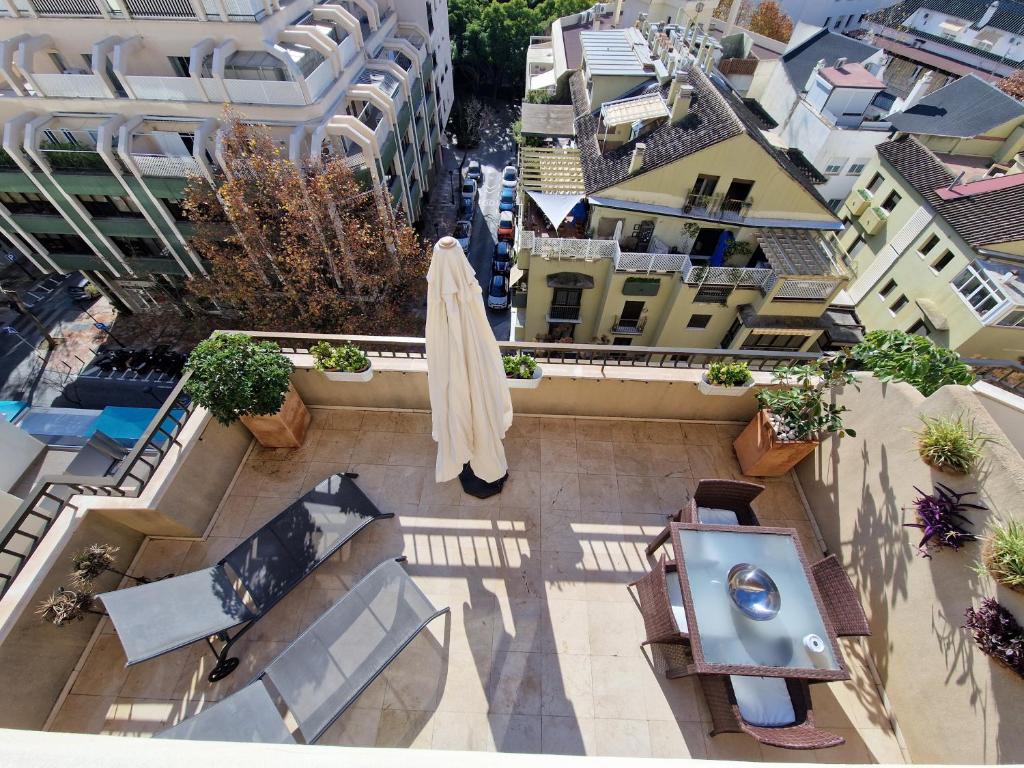 - une vue de tête sur une terrasse avec un parasol et des bâtiments dans l'établissement Polo Apartments 7B, à Marbella