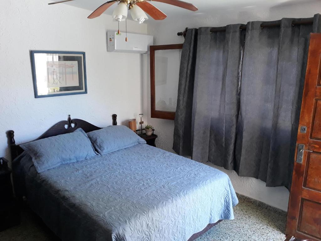 um quarto com uma cama e uma ventoinha de tecto em Suíte em Punta del Este