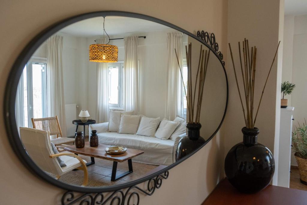 a living room with a white couch and a mirror at Knots apartments in Ágios Nikólaos