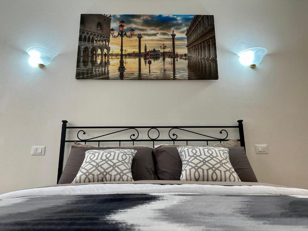een slaapkamer met een bed met een schilderij aan de muur bij New Apartment Venice 1 in Venetië