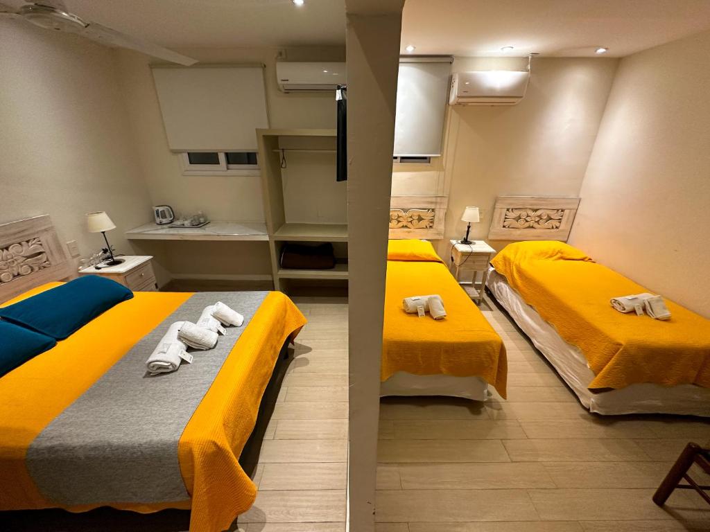 twee bedden in een kleine kamer met gele bedden bij Hotel ICONICO JUJUY Centro in San Salvador de Jujuy