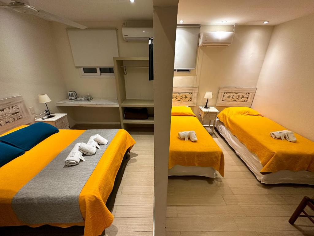 two beds in a small room with yellow beds at Hotel ICONICO JUJUY Centro Desayuno incluido in San Salvador de Jujuy