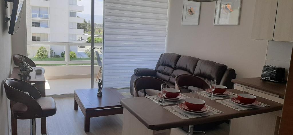 ein Wohnzimmer mit einem Tisch, Stühlen und einem Sofa in der Unterkunft Bonito y Acogedor Dpto Av Pacífico 3100, La Serena in La Serena