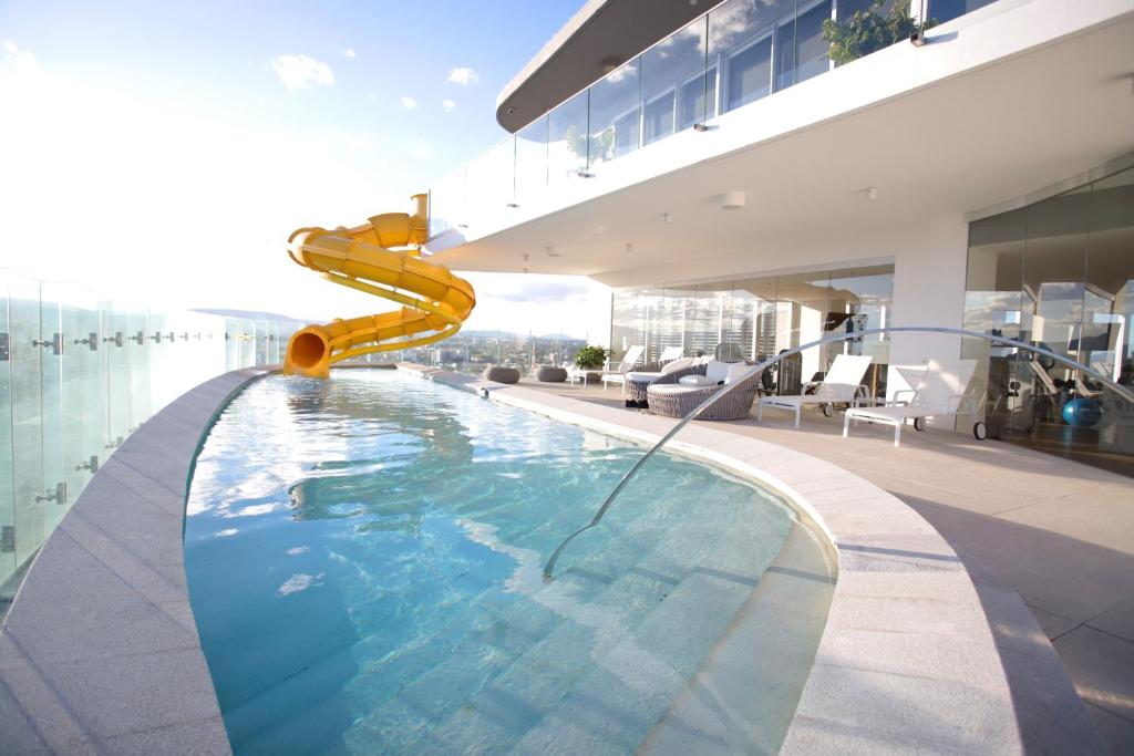 una piscina con un tobogán en el lateral de un edificio en LUXETOWN - A luxury experience with pool and gym, en Guadalajara