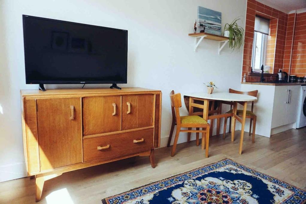 a living room with a television on a dresser at Clee Ness - 1 bed maisonette, on the seafront in Cleethorpes