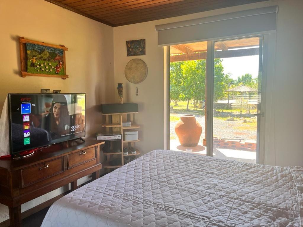 1 dormitorio con 1 cama, TV y ventana en Casa Campestre, en Molina