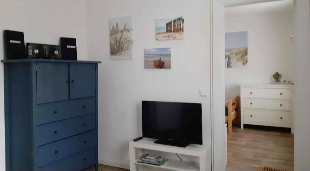 a living room with a tv and a blue dresser at Ferienwohnung und Monteurwohnung Schulz in Königs Wusterhausen