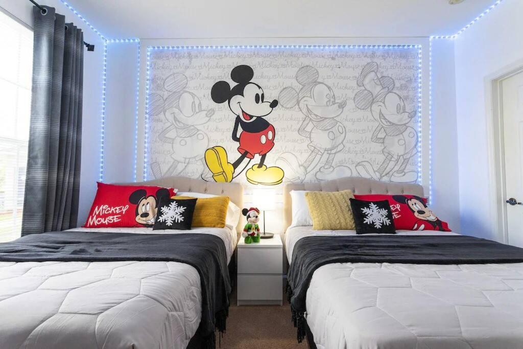a bedroom with two beds and a mickey mouse mural at Your Orlando stay 15 min to Disney - DVH01 in Kissimmee