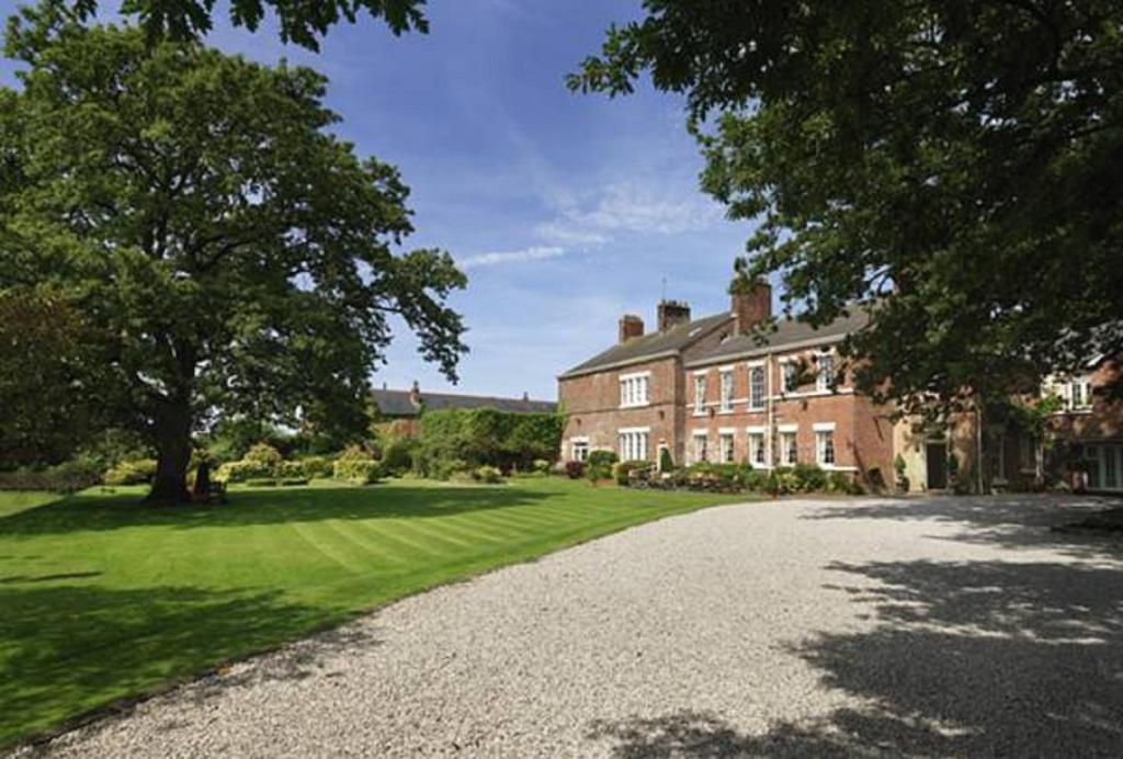 a large house with a driveway in front of it at Singleton Lodge Country House Hotel in Poulton le Fylde