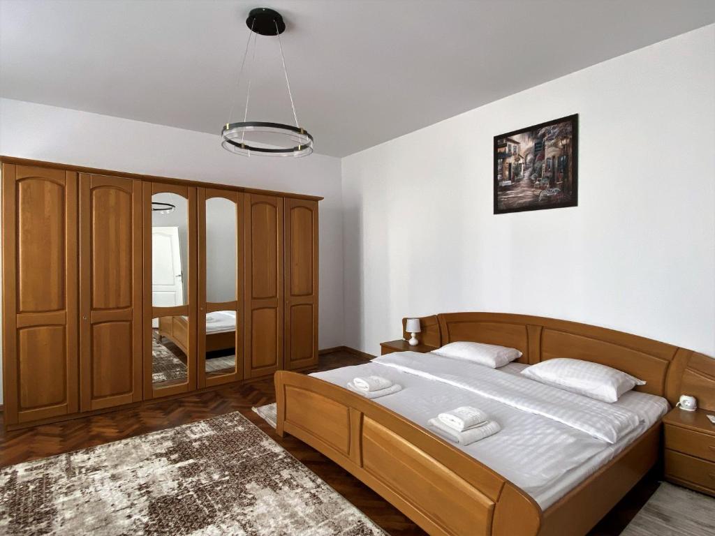1 dormitorio con 1 cama con muebles de madera en Ely`s Place, en Sibiu