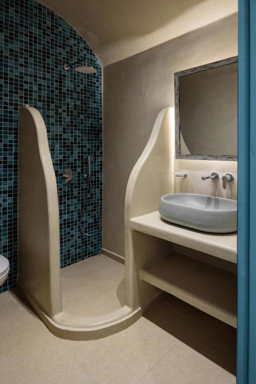 a bathroom with a sink and a shower with a mirror at Armonia in Kamari