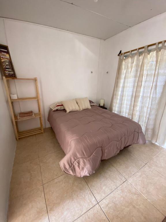 ein Schlafzimmer mit einem Bett in einem Zimmer mit Vorhängen in der Unterkunft El três in Chuy
