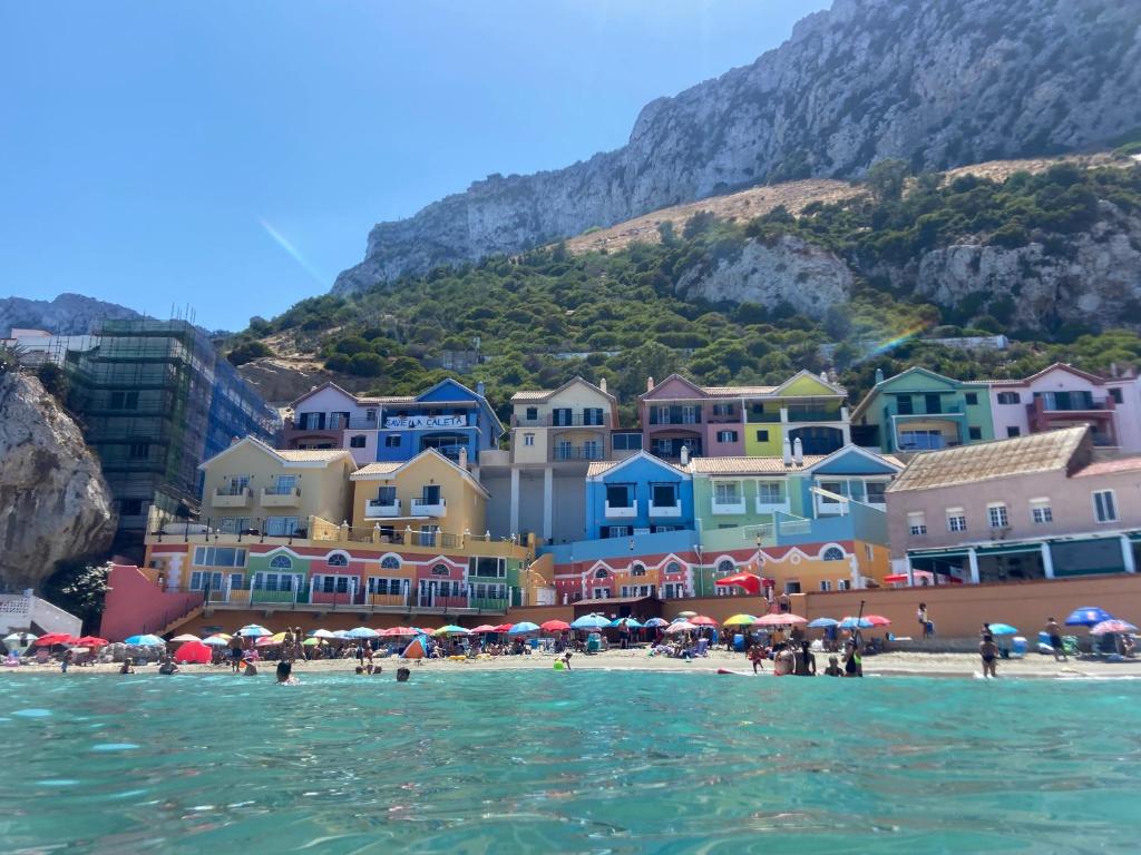 een uitzicht op een strand met kleurrijke gebouwen en de oceaan bij Unique Waterfront Duplex on the Mediterranean - Caleta, Catalan Bay in Gibraltar