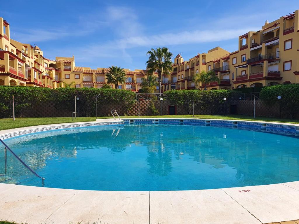 a large swimming pool in front of some apartments at Albatros Golf Costa Esuri Ayamonte Huelva in Huelva