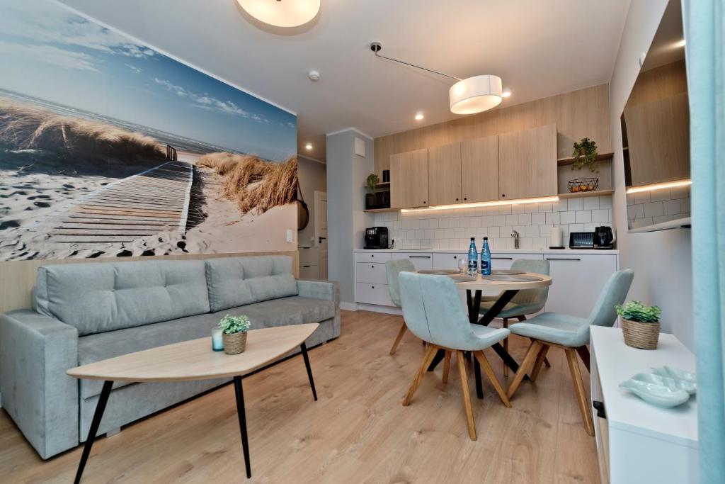Apartament Zatoka 12 في بوك: مطبخ وغرفة معيشة مع أريكة وطاولة