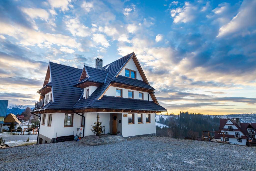 uma casa com um telhado azul numa colina em Sielanka w górach em Gliczarów Górny