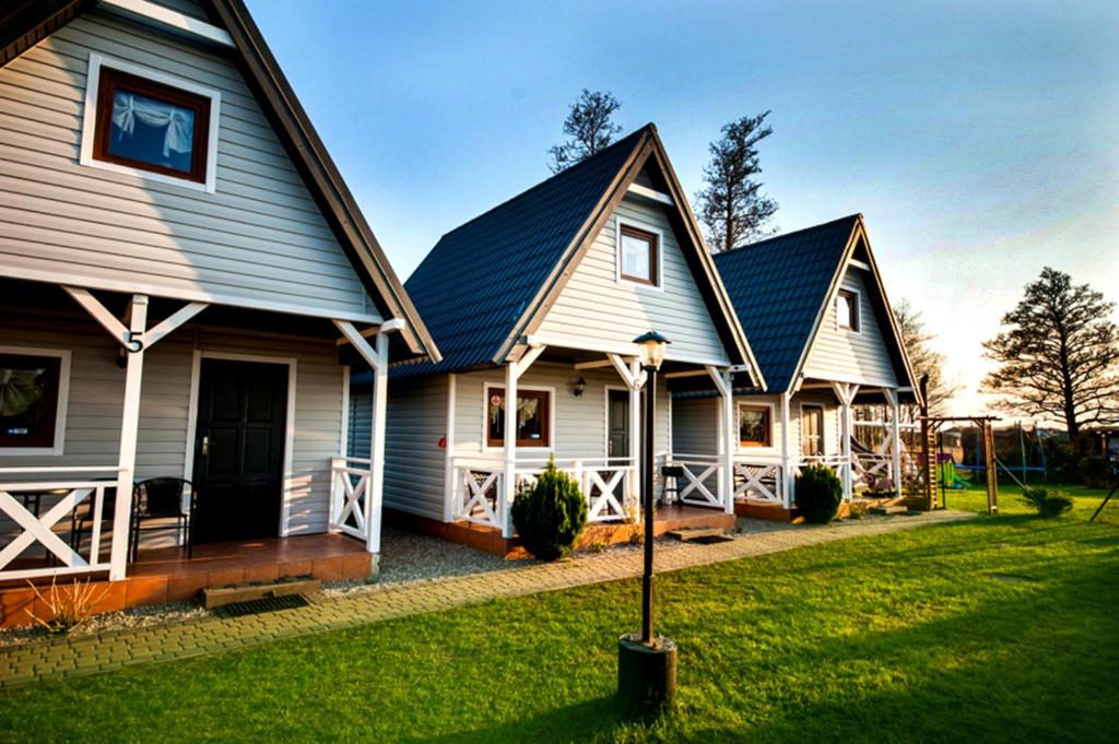 two large white houses with a yard at CUBA domki letniskowe in Sarbinowo