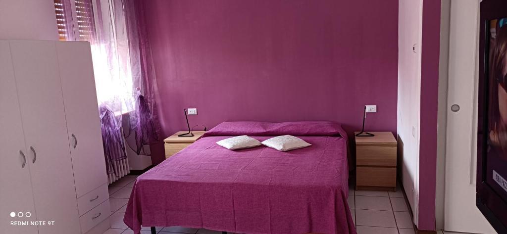 1 dormitorio púrpura con 1 cama con 2 almohadas en Appartamento tra Como e Milano, en Bregnano