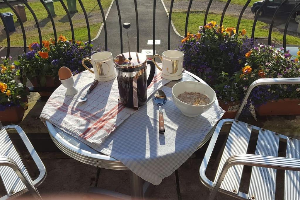 a table with utensils on top of it with flowers at South Lake House - 300m to South Lake Leisure Centre in Derrymacash