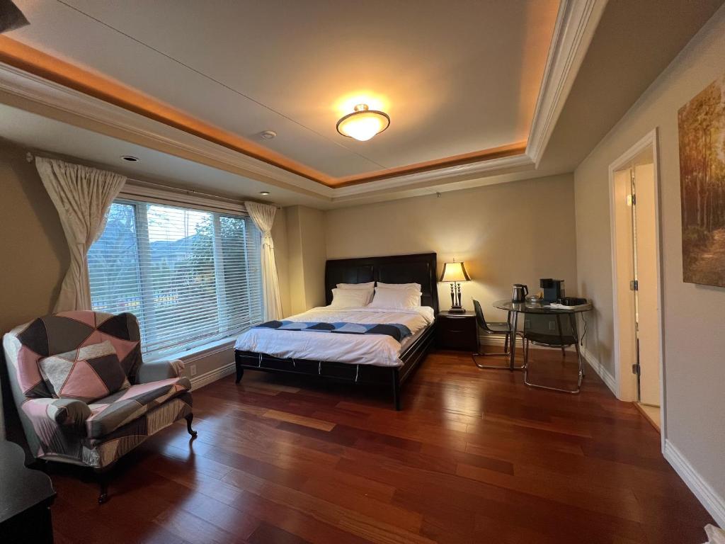 a bedroom with a bed and a chair and a window at Lucky suite, two-bedroom suite in Richmond close to YVR in Richmond