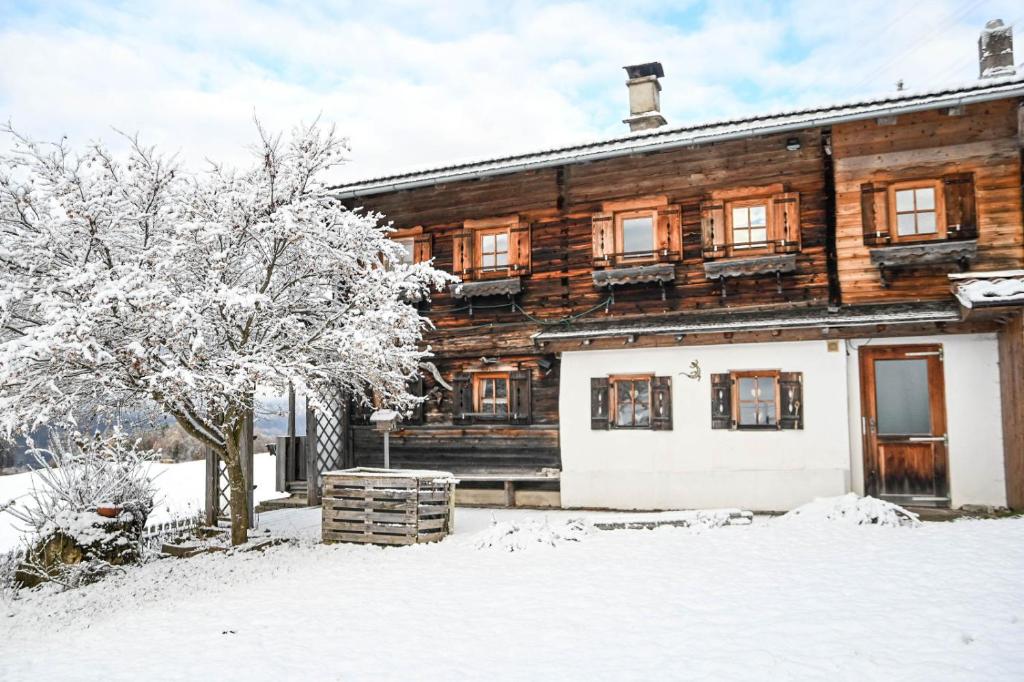 ein Holzhaus im Schnee in der Unterkunft Haus Prantl in Gallzein