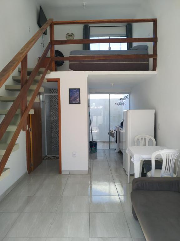 a living room with a staircase and a couch at Loft/APTO em Praia da Pinheira in Pinheira