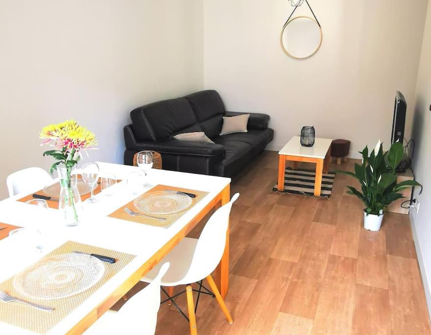 - un salon avec une table et un canapé noir dans l'établissement Maison 2 chambres, 6 pers - Wifi et Linge inclus - Niort centre, à Niort