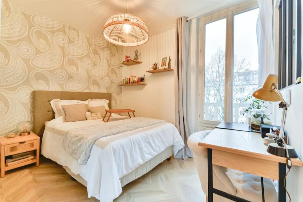 a bedroom with a bed and a desk and a window at Joli appartement bois de Vincennes, metro 1, rer A in Vincennes