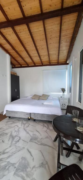 a bedroom with a large bed and a table at Apartaestudio de paso aeropuerto in Girón
