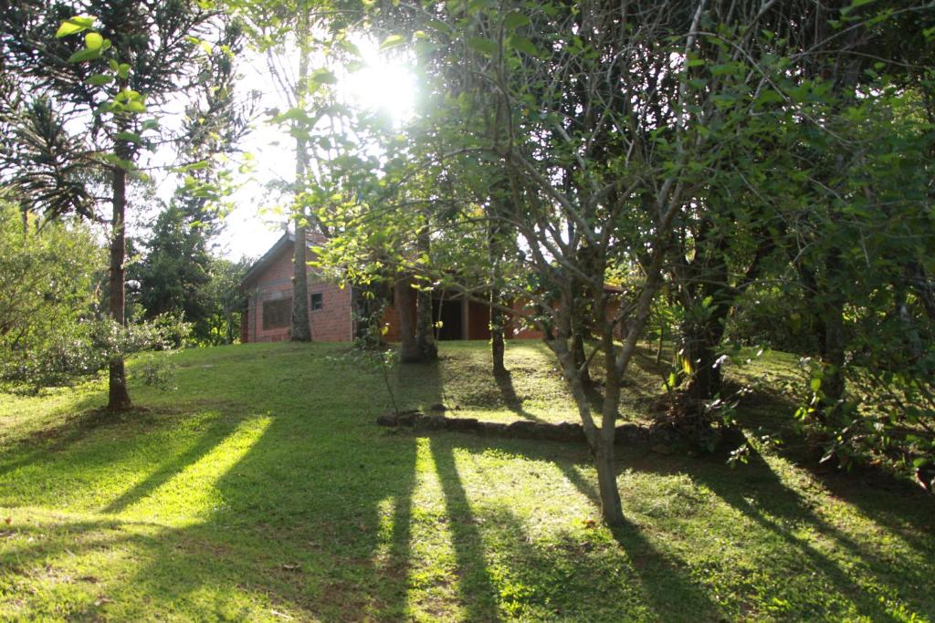 a house in the middle of a yard with trees at Casa de Campo - Sítio da tia Vera in Maquiné