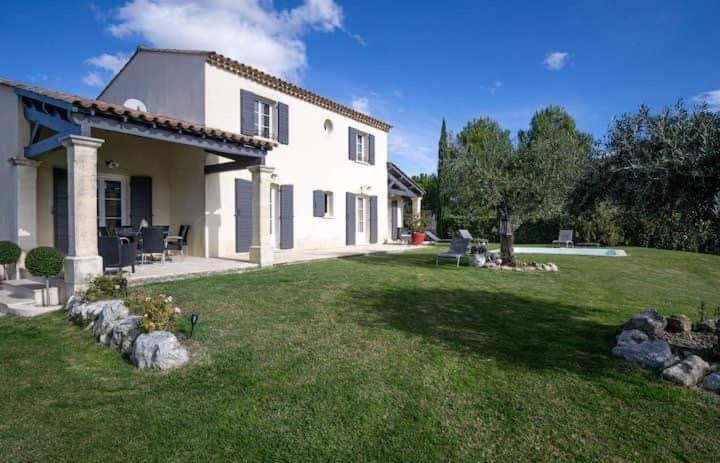 Une grande maison blanche avec une cour recouverte d'herbe dans l'établissement La marinette, à Fontaine-de-Vaucluse