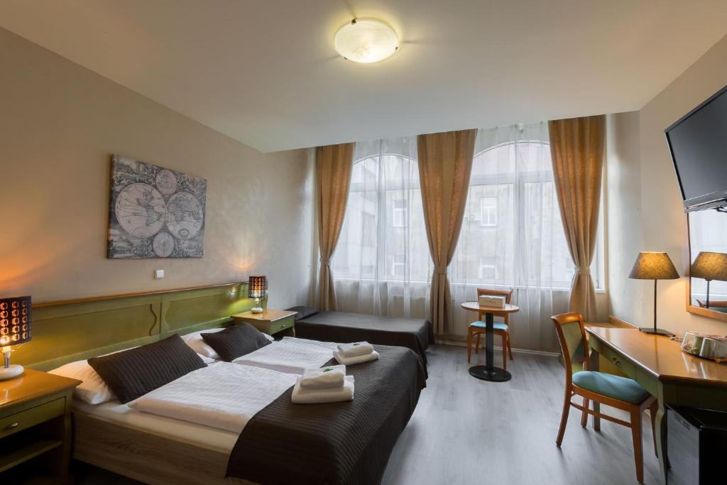 Hotel Augustus et Otto في براغ: غرفة في الفندق بها سرير ومكتب وبه جهاز كمبيوتر