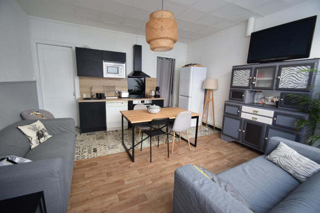 Il comprend un salon avec une table et une cuisine. dans l'établissement La Maison du Bonheur - Lille, à Lille